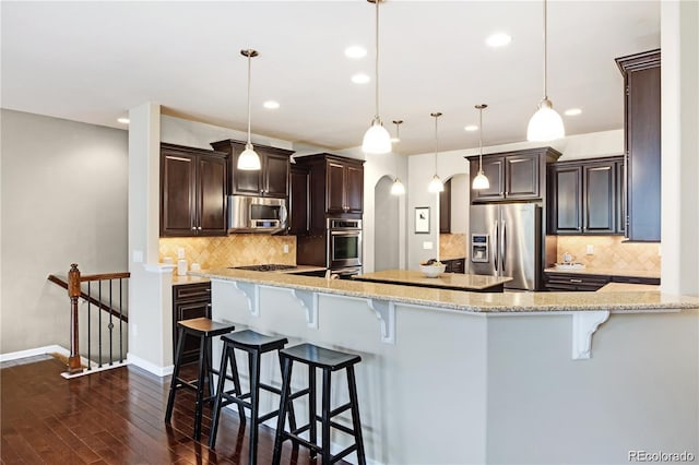 27235 E Lakeview Pl, Aurora, CO 80016 - kitchen featuring appliances with stainless steel finishes, dark wood-style flooring, recessed lighting, decorative backsplash, and dark brown cabinetry