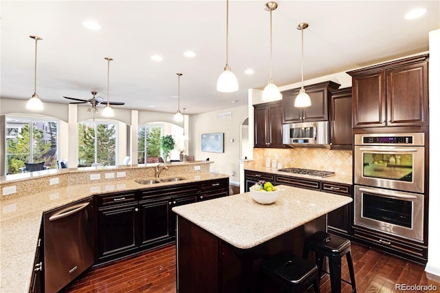 27235 E Lakeview Pl, Aurora, CO 80016 - kitchen with appliances with stainless steel finishes, arched walkways, dark wood finished floors, tasteful backsplash, and a kitchen breakfast bar