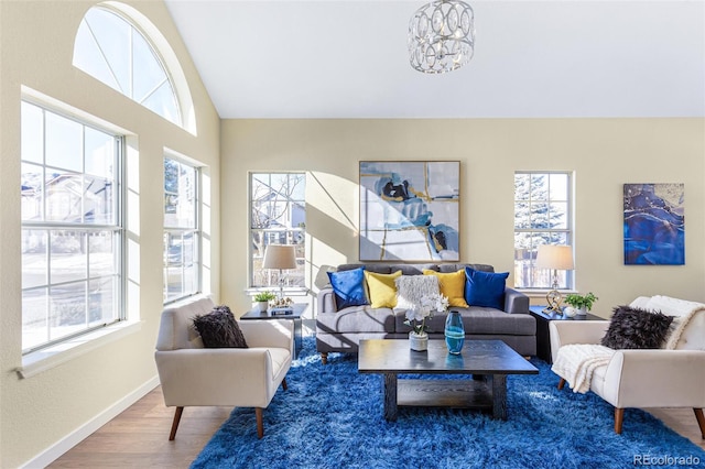 living room with lofted ceiling, a notable chandelier, and wood-type flooring