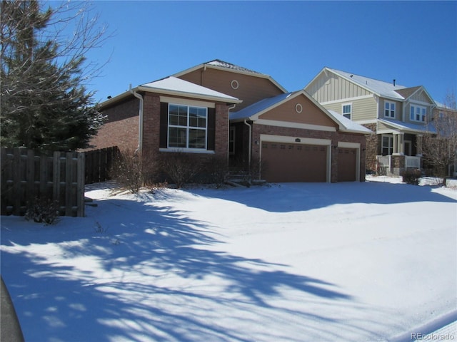 view of front of property with a garage, brick siding, and fence