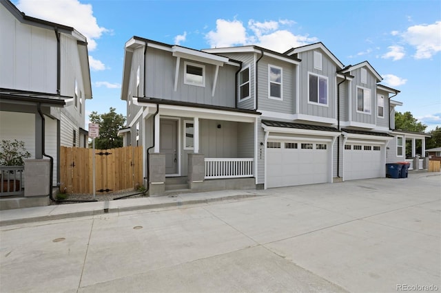 view of property featuring fence, a garage, concrete driveway, board and batten siding, and a porch