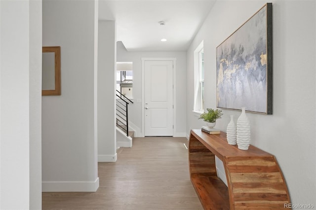 hall with stairs, recessed lighting, wood finished floors, and baseboards