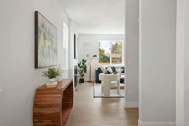 hallway featuring baseboards and wood finished floors