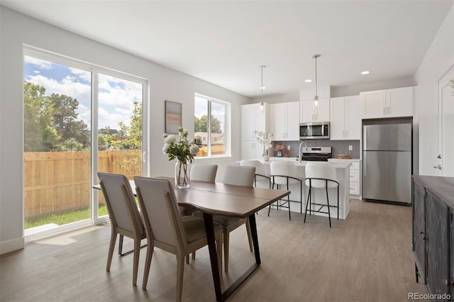 dining area with light wood-style flooring and recessed lighting