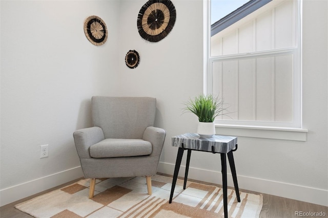 sitting room with baseboards and wood finished floors
