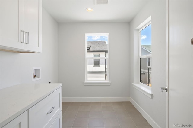 clothes washing area featuring washer hookup, cabinet space, a wealth of natural light, and baseboards