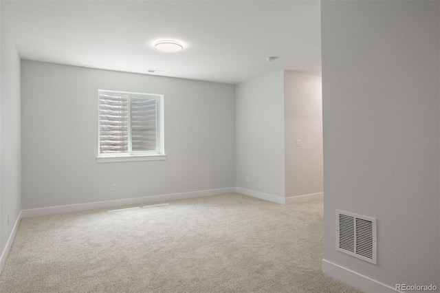 carpeted spare room featuring baseboards and visible vents