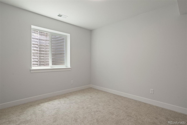 spare room featuring baseboards, visible vents, and carpet