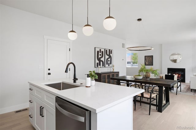 4020 Upham St, Wheat Ridge, CO 80033 - kitchen with a sink, light wood-type flooring, dishwasher, pendant lighting, and white cabinetry