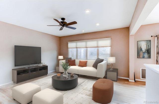 living room featuring light wood-style flooring, a ceiling fan, and baseboards