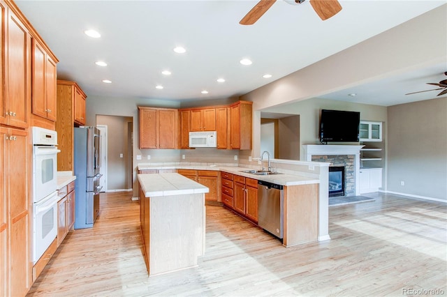 kitchen featuring open floor plan, a center island, a ceiling fan, and appliances with stainless steel finishes