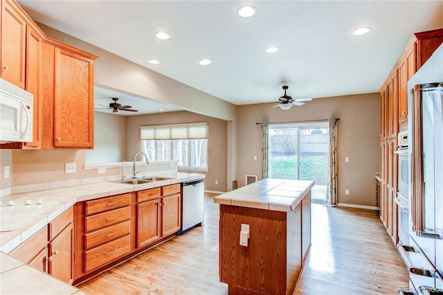 kitchen featuring tile counters, white appliances, a sink, and ceiling fan