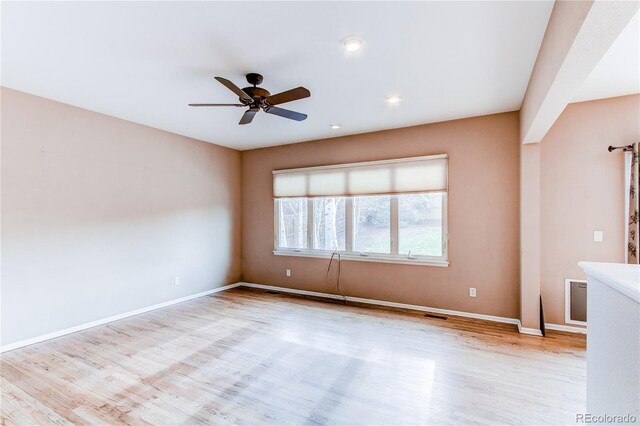 unfurnished room with ceiling fan, wood finished floors, and baseboards