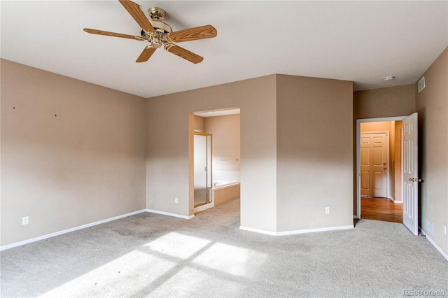 empty room featuring light carpet, visible vents, baseboards, and ceiling fan