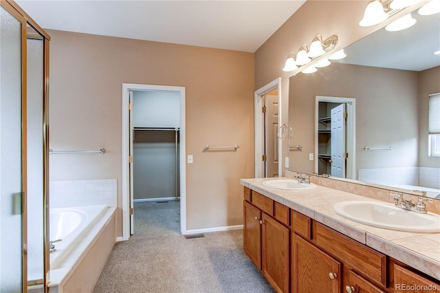 full bath with a spacious closet, a bath, and a sink