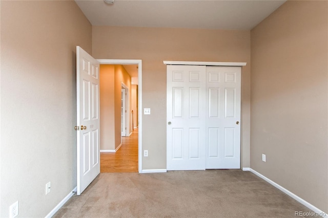 unfurnished bedroom featuring a closet, baseboards, and carpet floors