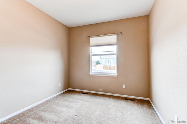 spare room featuring baseboards, carpet, and visible vents