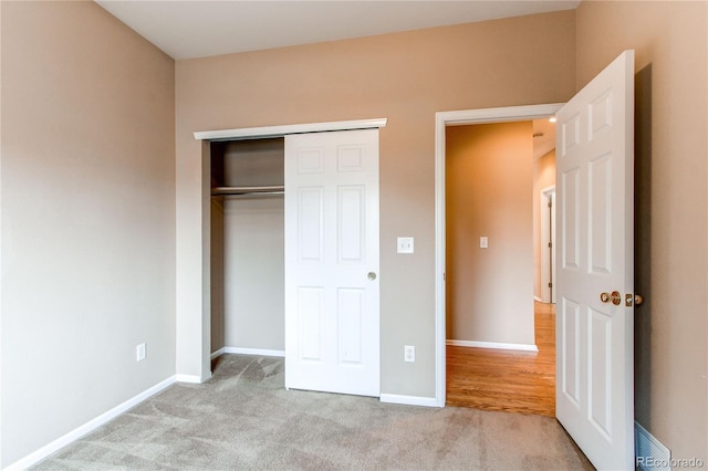 unfurnished bedroom with a closet, baseboards, and carpet floors