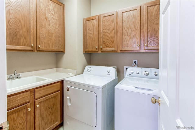 laundry room featuring cabinet space, separate washer and dryer, and a sink