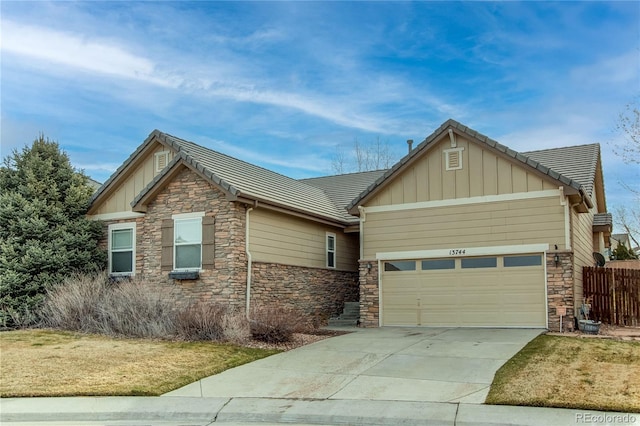 craftsman house with a tiled roof, an attached garage, stone siding, board and batten siding, and concrete driveway