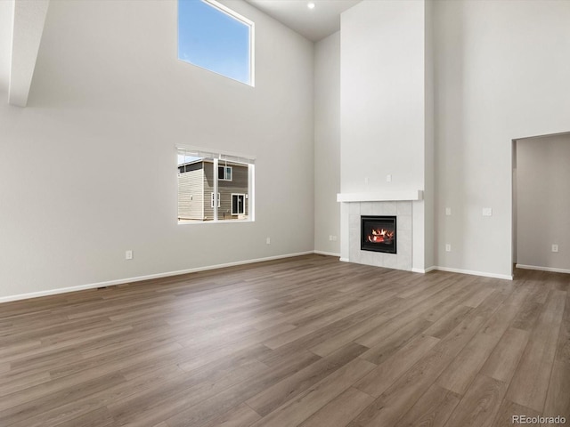1612 Colorado River Dr, Windsor, CO 80550 - unfurnished living room featuring a high ceiling, wood finished floors, and a fireplace