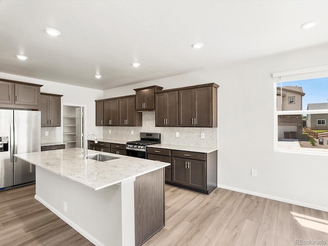 1612 Colorado River Dr, Windsor, CO 80550 - kitchen with stainless steel appliances, dark brown cabinets, light wood-type flooring, decorative backsplash, and recessed lighting