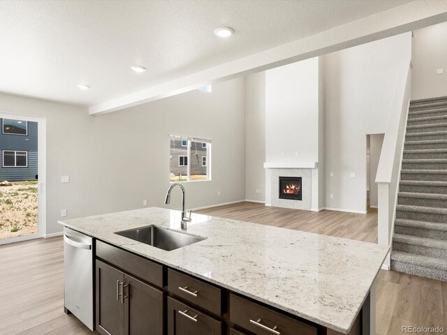 1612 Colorado River Dr, Windsor, CO 80550 - kitchen featuring dishwasher, light wood-type flooring, dark brown cabinets, an island with sink, and recessed lighting