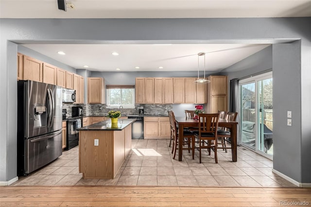 291 Las Lomas St, Brighton, CO 80601 - kitchen featuring black appliances, dark countertops, light brown cabinetry, light wood-type flooring, and backsplash