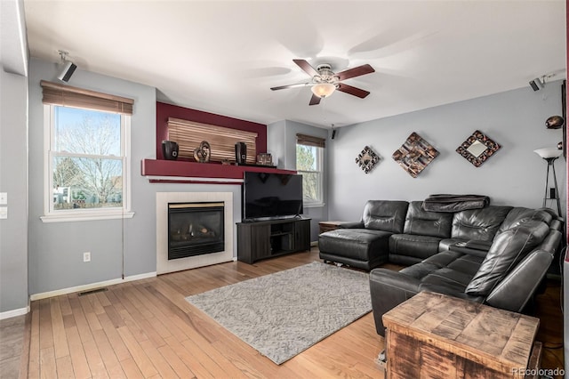 291 Las Lomas St, Brighton, CO 80601 - living room featuring a ceiling fan, healthy amount of natural light, wood finished floors, and a tiled fireplace