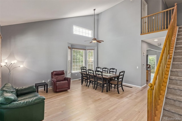 291 Las Lomas St, Brighton, CO 80601 - dining area featuring stairs, light wood-style flooring, ceiling fan, and high vaulted ceiling