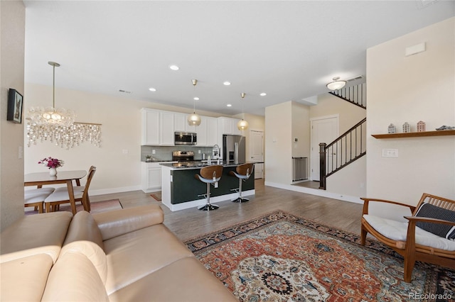 4177 E 98th Pl, Thornton, CO 80229 - living area with stairway, light wood-style flooring, recessed lighting, and a chandelier