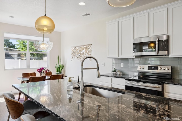 4177 E 98th Pl, Thornton, CO 80229 - kitchen with stainless steel appliances, white cabinetry, dark stone countertops, and recessed lighting