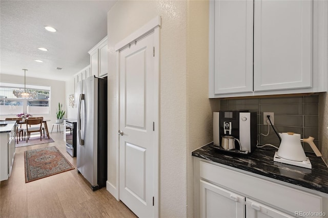 4177 E 98th Pl, Thornton, CO 80229 - kitchen featuring freestanding refrigerator, light wood-style flooring, white cabinets, recessed lighting, and pendant lighting