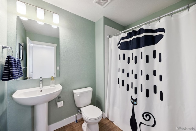 4177 E 98th Pl, Thornton, CO 80229 - bathroom featuring wood finished floors, a textured wall, and curtained shower