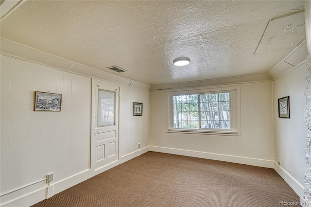 empty room featuring carpet flooring and a textured ceiling