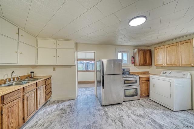 kitchen with washer / dryer, sink, and appliances with stainless steel finishes