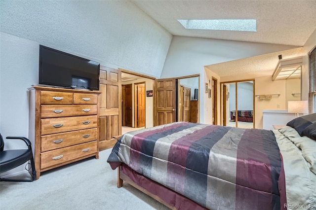 carpeted bedroom with a skylight, a textured ceiling, high vaulted ceiling, and a closet