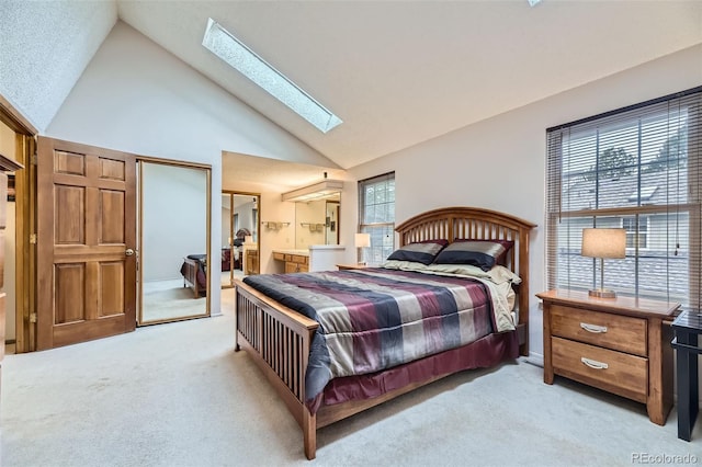 bedroom with a skylight, multiple windows, high vaulted ceiling, and light colored carpet