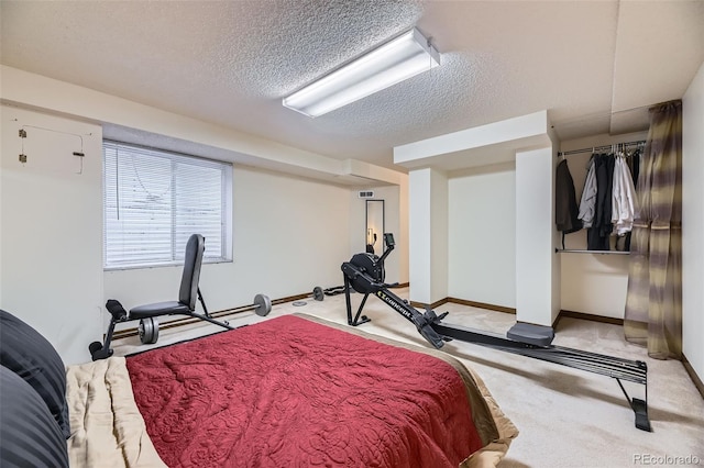 bedroom with a closet, light colored carpet, a textured ceiling, and baseboards