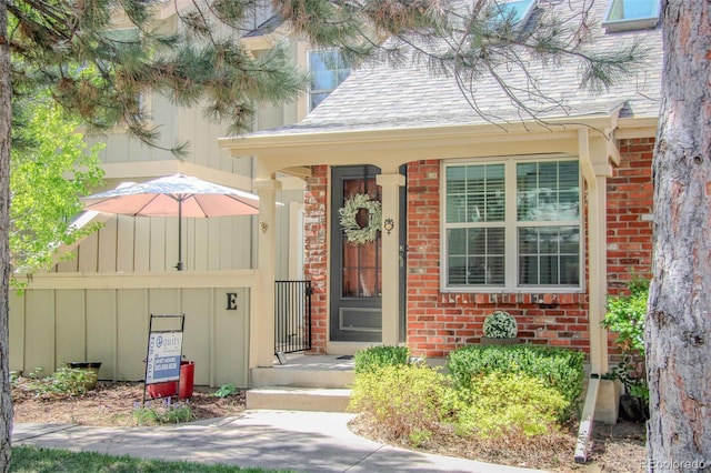doorway to property with board and batten siding and brick siding