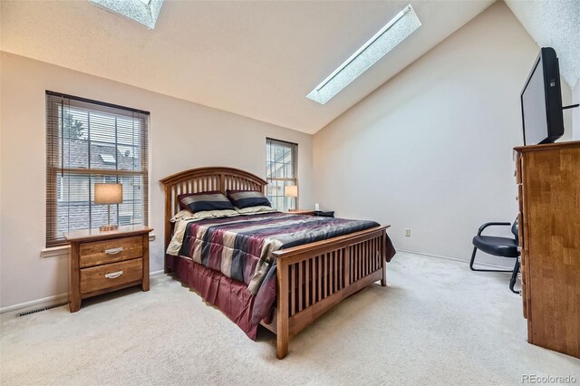 bedroom featuring visible vents, lofted ceiling with skylight, multiple windows, and light carpet