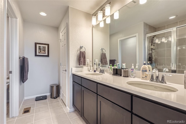 bathroom with tile patterned flooring, vanity, and walk in shower