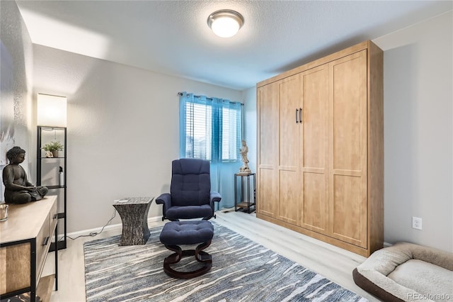 sitting room with light hardwood / wood-style flooring and a textured ceiling