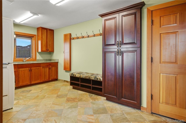 25803 Aspen Way, Golden, CO 80401 - mudroom with stacked washer / dryer, a sink, and baseboards