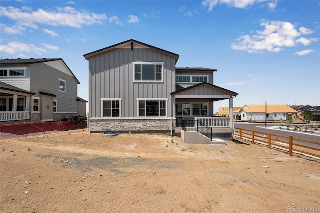 3394 N Grand Baker Ct, Aurora, CO 80019 - rear view of property with board and batten siding, stone siding, and a porch