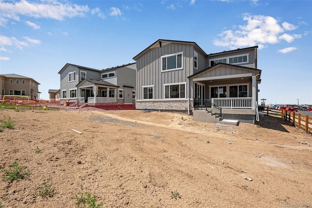 3394 N Grand Baker Ct, Aurora, CO 80019 - rear view of house featuring board and batten siding, a porch, and stone siding