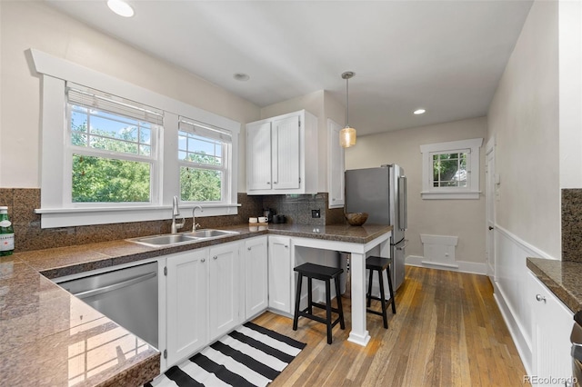 864 Garfield St, Denver, CO 80206 - kitchen featuring stainless steel appliances, light wood-style flooring, backsplash, white cabinetry, and recessed lighting