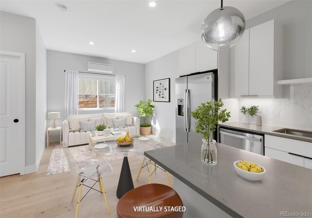 4232 Jason St Unit 2, Denver, CO 80211 - kitchen with appliances with stainless steel finishes, white cabinets, light wood-style flooring, modern cabinets, and a wall unit AC