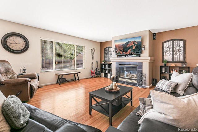 living room with hardwood / wood-style flooring and a tile fireplace