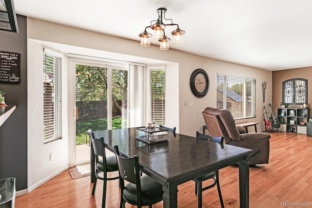 dining room featuring light wood-type flooring, an inviting chandelier, and a healthy amount of sunlight